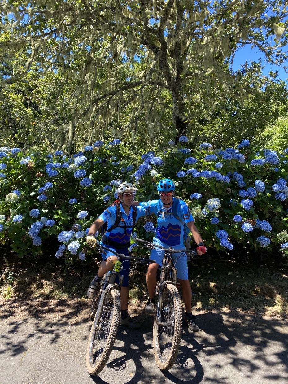 Bikeguides vor einem Blumenbusch